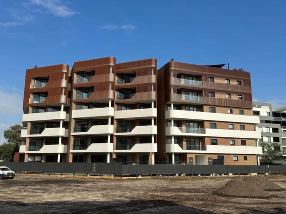 Exterior of the five level Blacktown apartment building in brick and timber cladding, with balconies to every level
